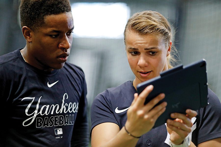 Rachel coaching with an ipad while a yankee player looks on