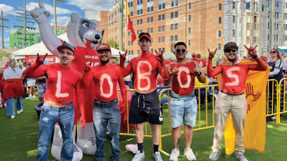 Fans spelling out Lobos at a UNM Alumni football tailgate
